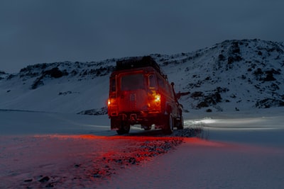 山坡附近雪地上的棕色SUV